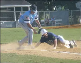  ?? STAFF PHOTO BY ANDY STATES ?? Calvert’s Eddie Harris slides safely back to first under the tag from La Plata Post 82’s Ryan Calvert during the teams’ American Legion game at La Plata High School on Tuesday night. La Plata defeated Calvert 12-2 in six innings.