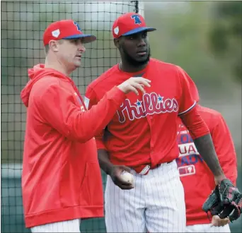  ?? LYNNE SLADKY — THE ASSOCIATED PRESS ?? Phillies pitching coach Chris Young, left, talks with relief pitcher Enyel De Los Santos during spring training. Young was dismissed as the team’s pitching coach on Friday.