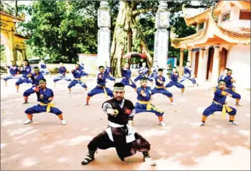  ?? AFP ?? Master Nguyen Khac Phan (centre) teaching students during a Thien Mon Dao training class. His school trains in the complex of an ornate temple on the outskirts of Hanoi.