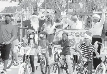  ?? RICK CASE BIKES FOR KIDS/COURTESY ?? Santa Claus with Raquel, Ryan and Rita Case deliver bikes to children in the Rick Case Habitat Community in Pompano Beach.