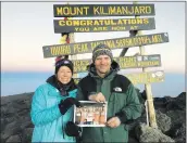  ?? Courtesy photo ?? Amy Daniels (left) and Joshua Powers (right) hold up a photo of their University of Vermont hiking team at the summit of Mt. Kilimanjar­o in September.