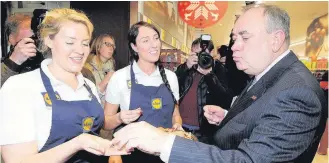  ??  ?? Good food First Minister Alex Salmond tries some free samples at Lidl in Rutherglen, with Karen Arrol (left) and Victoria Cochran (right)