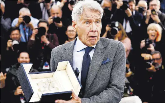  ?? YARA NARDI / REUTERS ?? Harrison Ford muestra la Palma de Oro honorífica que recibió el viernes por sorpresa en el festival de Cannes.