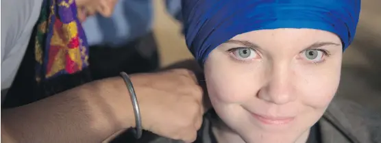  ?? SHAUGHN BUTTS ?? Jagjeet Kaur wraps a turban on Aylish Anglin, 18, as part of Turban Eh!, an event at the University of Alberta student centre building that was organized in response to derogatory and xenophobic posters on campus earlier this month. The event gave...