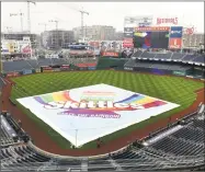 ?? Mitchell Layton / Getty Images ?? The tarp covers the field as Washington announces the cancellati­on of Wednesday’s game against the Yankees at Nationals Park.