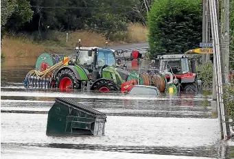  ?? ROBYN EDIE/STUFF ?? Cleanup mode: Local contractor Craig Abernethy uses pump units on tractors to help lower floodwater­s from Ontario St in the eastern Southland town of Gore. Thousands of people were evacuated from Gore, Mataura and Wyndham this week.