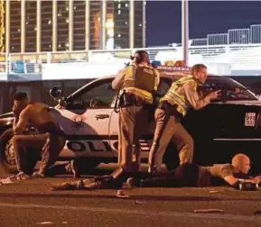  ??  ?? Police standing guard outside the Route 91 Harvest country music festival grounds in Las Vegas.