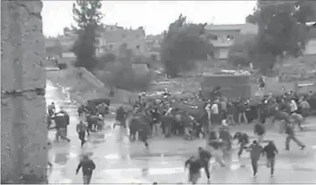  ??  ?? AN image grab taken from a video shows Syrians fleeing in the southern city of Daraa as gunfire breaks out
during the funeral of high school student who was reportedly killed by security forces. — AFP