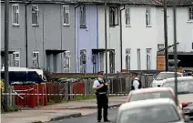  ??  ?? Police officers stand behind cordon tape near a property in Sunbury-on-Thames that was searched after an explosion on a London Undergroun­d train.