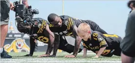  ?? GARY YOKOYAMA THE HAMILTON SPECTATOR ?? Jed Seehagel does some pushups with Ja'Gared Davis, left, and Brandon Banks of the Ticats. Jed and the Cats were filming a public service announceme­nt recently and got along famously.