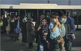  ?? Marcus Yam Los Angeles Times ?? AFGHAN newspaper founder Zaki Daryabi, right, prepares to board an evacuation f light with his wife, Humaira Rasa, and their children in Kabul in October.