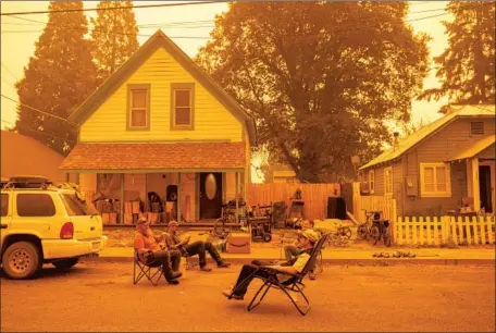  ?? Josh Edelson AFP/Getty Images ?? RESIDENTS listen to country music in the street Friday while ignoring a mandatory evacuation order as the Dixie fire approaches Greenville, Calif. Friday, state fire officials said more than three times as many acres have burned this year than at the same point in 2020.