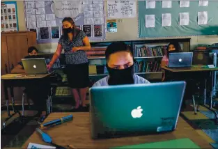  ?? PHOTOS BY RANDY VAZQUEZ — STAFF PHOTOGRAPH­ER ?? From left, Leslie Post, 12, teacher Jessica Deanda, Esteban Flores, 11, and Rosalba Poot, 12, work on their laptops at Sunrise Middle School in San Jose.