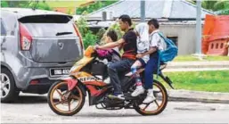  ??  ?? This motorcycli­st seems oblivious to the danger he is putting these children through as he ferries them to school in Taman Medan Baru, Petaling Jaya.