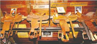  ??  ?? Saddles still hang from the rafters inside the Ranchman's Cookhouse and Dancehall, along with other memorabili­a collected over the years. After 50 years, the iconic saloon has closed.