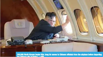  ??  ?? DALIAN: North Korean leader Kim Jong Un waves to Chinese officials from the airplane before departing the Chinese city of Dalian. —AFP