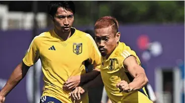  ?? — AFP ?? Morale booster: Japanese veteran yuto nagatomo (right) dyed his hair red for the tournament to fire up his teammates.