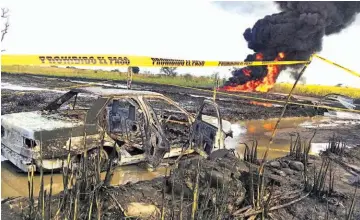  ??  ?? Víctimas. Hallaron cuatro cadáveres quemados y un vehículo calcinado en el lugar de la explosión.