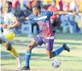  ?? NICHOLAS NUNES ?? Gawain Austin (right) of Portmore United FC shields the ball from Gregory Messam of Waterhouse FC during a Jamaica Premier League match at the Ferdie Neita Park in Greater Portmore, St Catherine, on April 30, 2023.