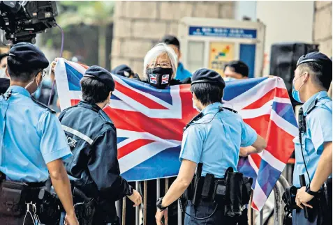  ??  ?? Alexandra Wong, a Hong Kong activist, waves a British flag outside the city’s High Court yesterday