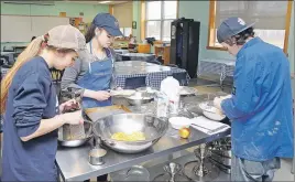  ?? ADAM MACINNIS/THE NEWS ?? Students prepare a meal for family members to see what they’ve learned over the course of the year. From left: Angela MacDonald, Shayleigh Fennell and Taylor Richardson.