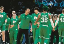  ?? STEVEN SENNE/AP ?? Celtics head coach Joe Mazzulla, center, celebrates with guard Marcus Smart (36) after their team scored in the second half against the Warriors on Jan. 19 in Boston.