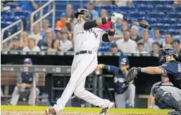  ?? DAVID SANTIAGO/MIAMI HERALD ?? Miami’s Starlin Castro hits a sacrifice fly to drive in teammate Brian Anderson during the fourth inning against Milwaukee on Wednesday night. The game between the Marlins and Brewers at Marlins Park was not over in time for this edition. Go to