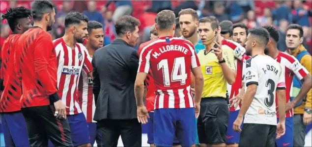  ??  ?? Simeone saltó al campo cuando terminó el partido del Atlético ante el Valencia para recriminar­le el tiempo añadido, pidiéndole más (sólo fueron 5’), rodeado de todos sus jugadores.