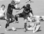  ?? STEPHEN M. DOWELL/ORLANDO SENTINEL ?? Orlando players Jhegson Mendez (left) and Alexandre Pato (7) try unsuccessf­ully to get the ball past Atlanta goalkeeper Brad Guzan (right) at Exploria Stadium on Saturday. The game ended in a 0-0 tie.