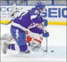  ?? Mike Carlson The Associated Press ?? Tampa Bay’s Yanni Gourde scores the winner in overtime, beating Carolina goaltender Petr Mrazek for a 3-2 victory.