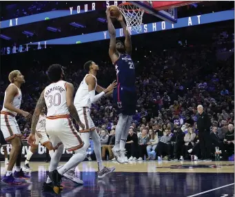  ?? MATT SLOCUM — THE ASSOCIATED PRESS ?? Philadelph­ia 76ers’ Joel Embiid, right, goes up for a dunk past San Antonio Spurs’ Victor Wembanyama during the first half of an NBA basketball game, Monday, Jan. 22, 2024, in Philadelph­ia.