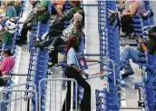  ?? Kin Man Hui / Staff photograph­er ?? An Alamodome usher carries a sign to remind spectators to wear a mask during the Baylor-jackson State game in the NCAA women’s tournament.