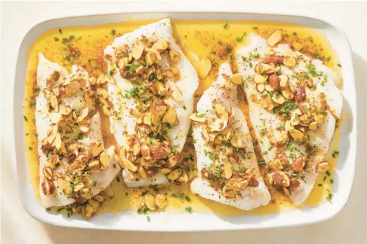  ?? JULIA GARTLAND/THE NEW YORK TIMES PHOTOS ?? Fish almondine is a nutty variation on a French classic, sole meuniere. Any fish works, particular­ly lean flaky fillets, for this roasted dish.