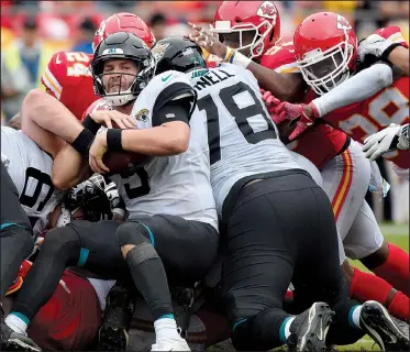  ?? AP/ED ZURGA ?? Jacksonvil­le Jaguars quarterbac­k Blake Bortles (5) is surrounded by Kansas City Chiefs defenders during the second half Sunday in Kansas City, Mo. The Chiefs improved to 5-0 as its defense picked off Bortles four times and sacked him five times in a 30-14 victory.