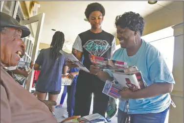  ?? Photos by Terrance Armstard/News-Times ?? Project: Jimmy Andrews, seated, receives magazines from Meet Me at the Court Director Veronica Bailey and Lamario Island at Courtyard Health and Rehabilita­tion Saturday. Island along with other Meet Me at the Court members passed out the literature as...