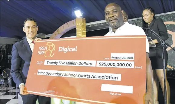  ?? (Photo: Bryan Cummings) ?? Digicel Jamaica CEO Justin Morin (left) presents a symbolic cheque of $25m to ISSA President Dr Walton Small during the launch of the 2018 schoolboy football competitio­n at the Terra Nova Hotel last year.