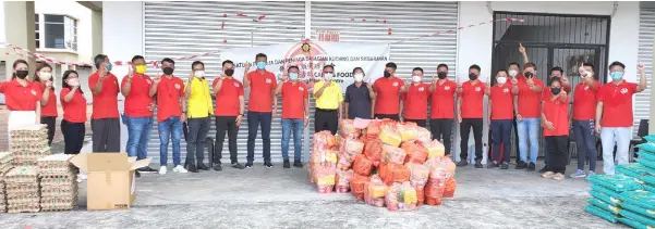  ?? — Photo sent by Dato Sim Kiang Chiok ?? Officials and members of the Kuching and Samarahan Division Hawkers and Traders Associatio­n with Sim (seventh left) and Lo (11th left) in a photo call during their Caring Food Aid 3.0 event at Eastgate Mall, 9th Mile Kuching-Serian Road last week.