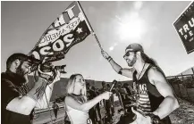  ?? Roger Kisby / Bloomberg ?? A Trump rally attendee holds a campaign flag while speaking to reporters ahead of a gathering in Henderson, Nev.