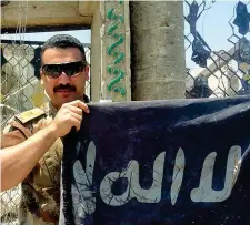  ??  ?? Bandiera Un soldato con la bandiera di Isis trovata vicino alla moschea (Foto Bicicchi)