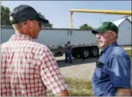  ?? THE ASSOCIATED PRESS ?? Farmer Don Bloss, right, talks to his son Mark as a grain truck is being loaded with corn in Pawnee City, Neb.