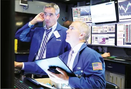  ??  ?? In this file photo, traders Daniel Trimble, (left), and Timothy Nick work on the floor of the New York Stock Exchange. (AP)