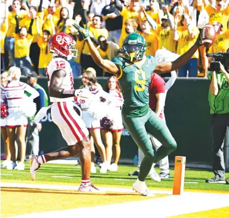  ?? ERNESTO GARCIA/WACO TRIBUNE-HERALD VIA AP ?? Baylor wide receiver Tyquan Thornton celebrates his touchdown in front of Oklahoma defensive back Key Lawrence in the first half Saturday in Waco, Texas. The 18th-ranked Bears defeated No. 8 Oklahoma 27-14. The Sooners had won 17 games in a row before the Big 12 setback.