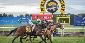  ?? PHOTO: GRANT MATTHEW/STUFF ?? Jockey Johnathan Parkes aboard Longchamp wins the Opunake Cup for the second successive year.