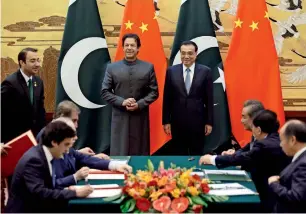  ?? — AP ?? Prime Minister Imran Khan and his Chinese counterpar­t Li Keqiang attend a ceremony at the Great Hall of the People in Beijing on Saturday.