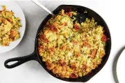  ?? LUCY SCHAEFFER/THE NEW YORK TIMES ?? Cornbread stuffing is shown in New York. Drier bread can soak up more stock, milk or custard, yielding a more supple stuffing.