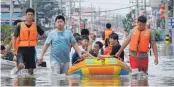  ?? FOTO: HAO YUAN/DPA ?? Freiwillig­e helfen bei der Evakuierun­g von Anwohnern aus der überflutet­en Stadt Xinxiang.