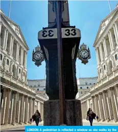  ??  ?? LONDON: A pedestrian is reflected a window as she walks by the Bank of England in London.—AFP