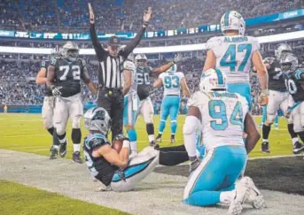  ??  ?? Christian McCaffrey of the Carolina Panthers scores one of his two touchdowns Monday night against the Miami Dolphins. McCaffrey has scored five times as a rookie.