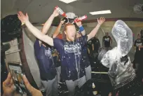  ?? JULIO CORTEZ/ASSOCIATED PRESS ?? Dodgers pitcher Dustin May, center, is doused Tuesday during a locker room celebratio­n after the Dodgers defeated the Orioles 7-3 in Baltimore. The Dodgers clinched the NL West title for the seven year in a row.