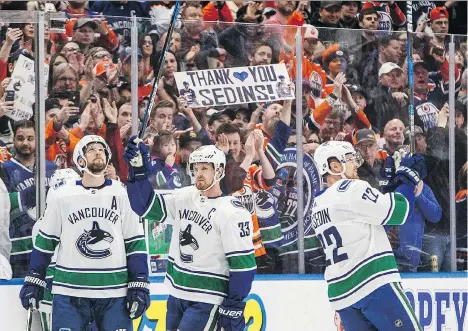  ?? JASON FRANSON/THE CANADIAN PRESS ?? Canucks Henrik, centre, and Daniel Sedin, right, acknowledg­e the cheers for them in Edmonton on Saturday.